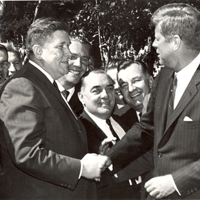 John F. Kennedy photographed in another Masonic handshake with Patrick J Mellody, Lackawanna County Democratic chairman. Looking on from left, Edward Zipay, Santo Pacoe and Edward Popil